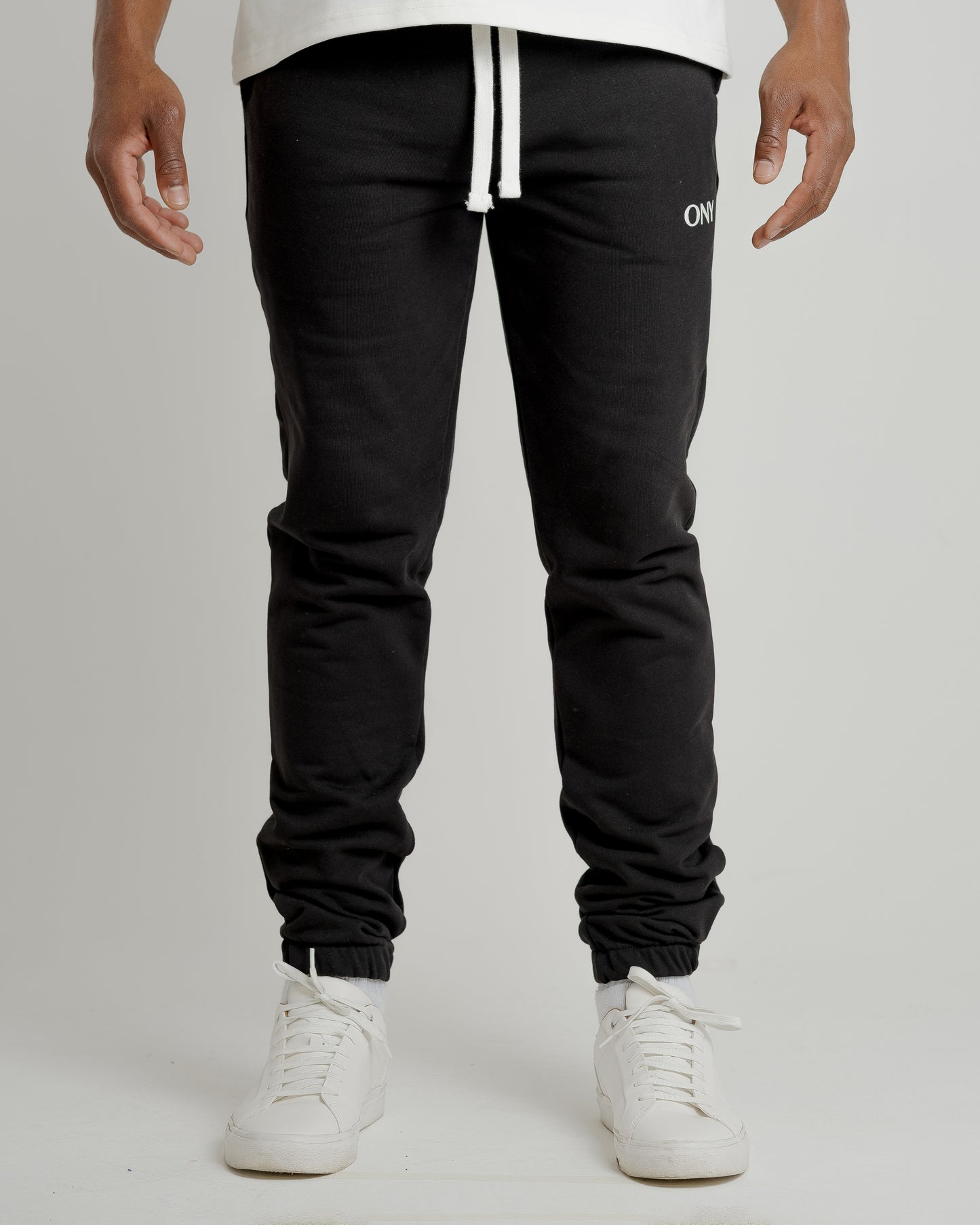 A male model showcasing our black sweatpants, combining comfort and style in a versatile wardrobe essential.