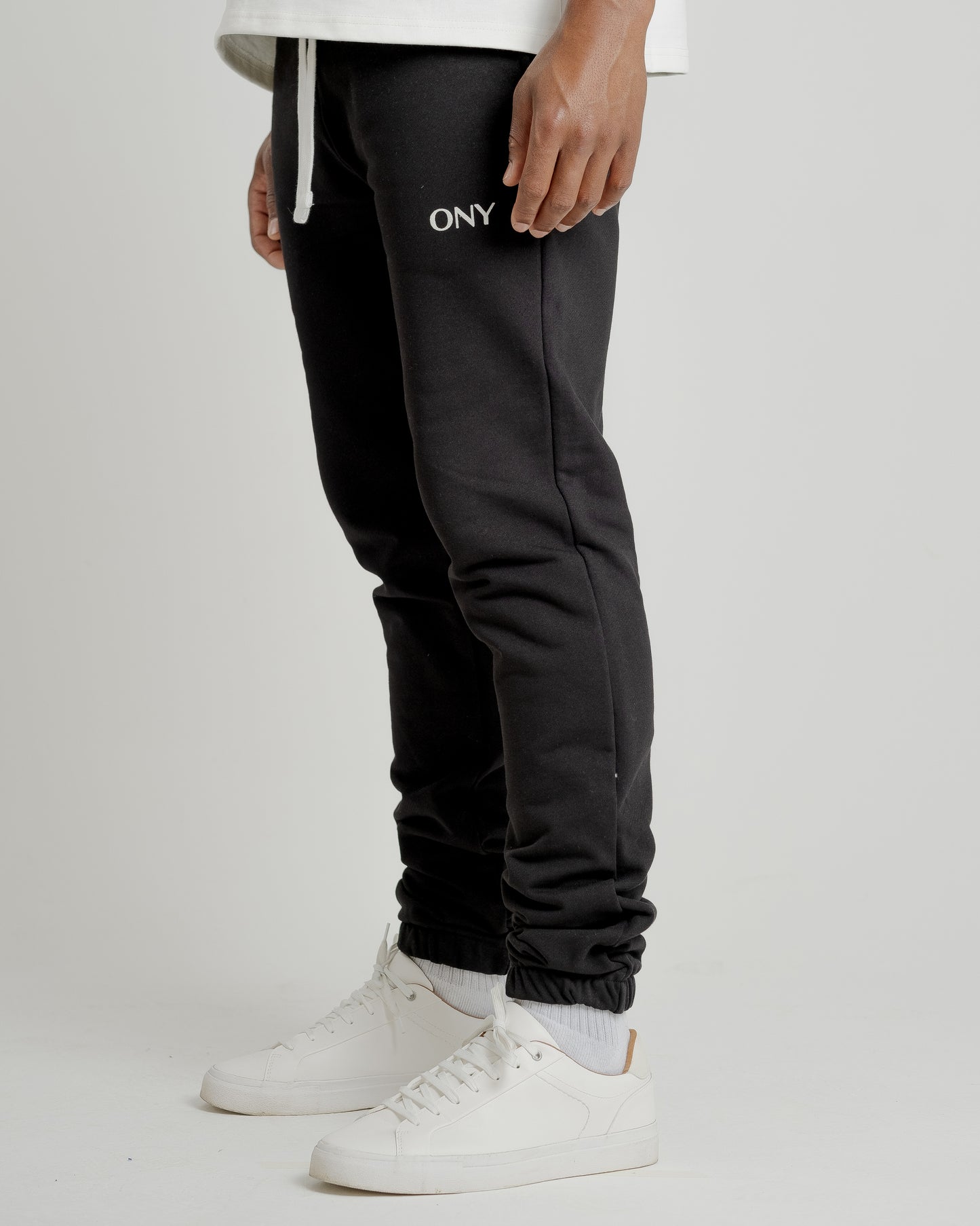A male model showcasing our black sweatpants, combining comfort and style in a versatile wardrobe essential.