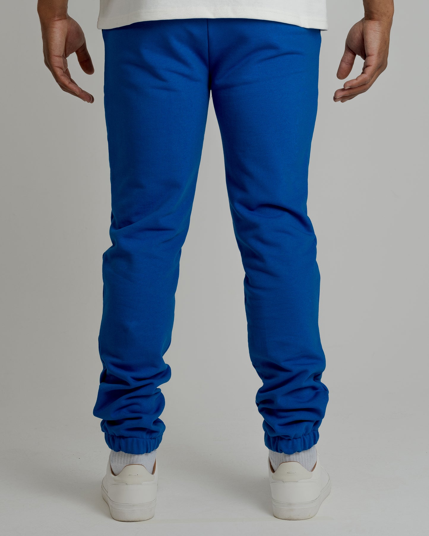 A male model showcasing our blue sweatpants, combining comfort and style in a versatile wardrobe essential.