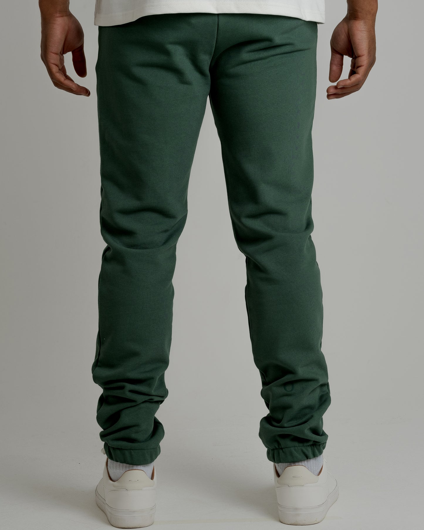 A male model showcasing our green sweatpants, combining comfort and style in a versatile wardrobe essential.