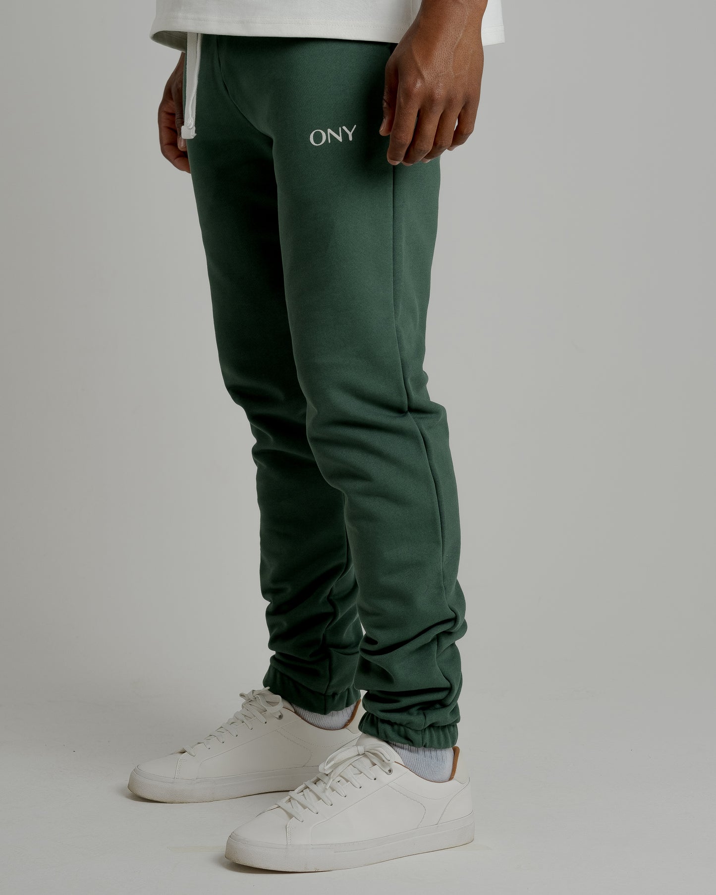 A male model showcasing our green sweatpants, combining comfort and style in a versatile wardrobe essential.
