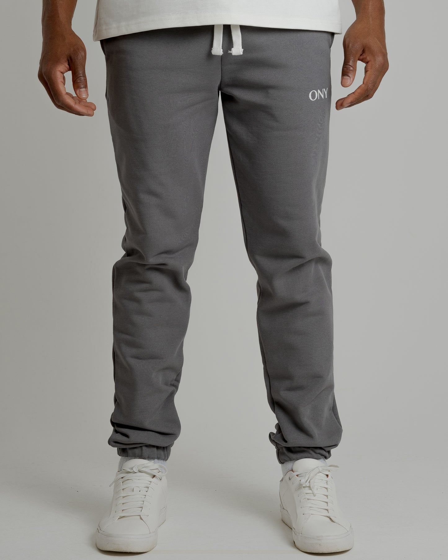 A male model showcasing our grey sweatpants, combining comfort and style in a versatile wardrobe essential.