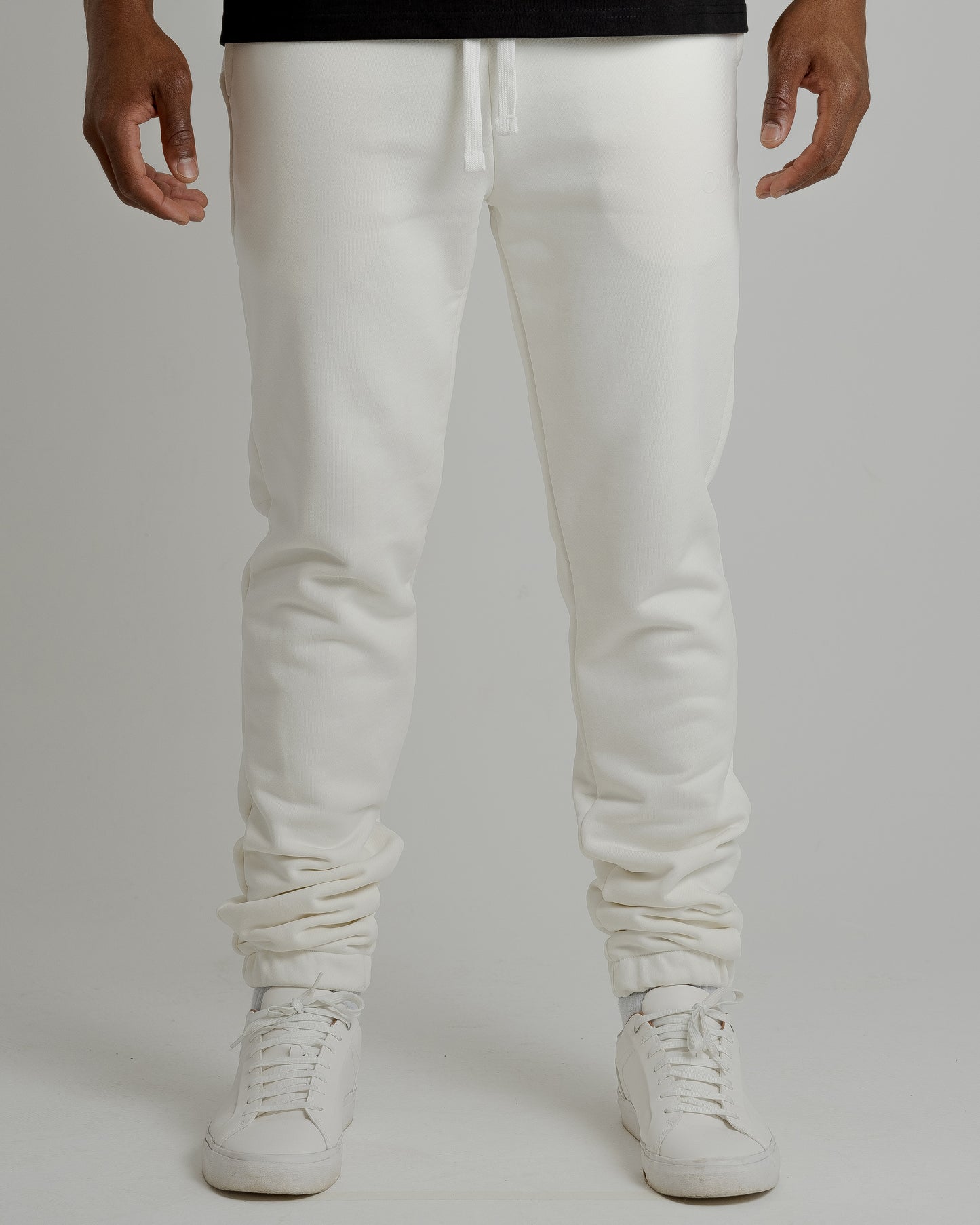 A male model showcasing our off-white sweatpants, combining comfort and style in a versatile wardrobe essential.