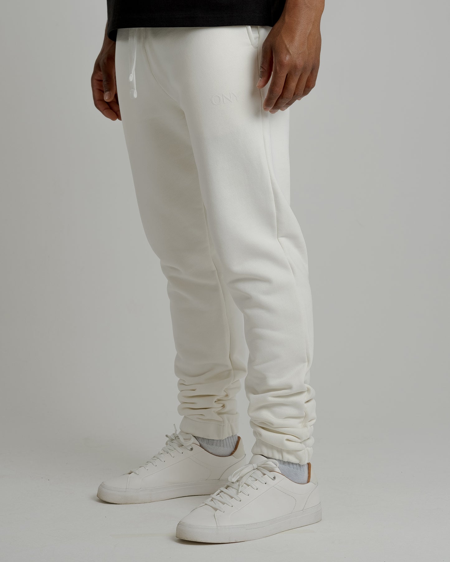A male model showcasing our off-white sweatpants, combining comfort and style in a versatile wardrobe essential.