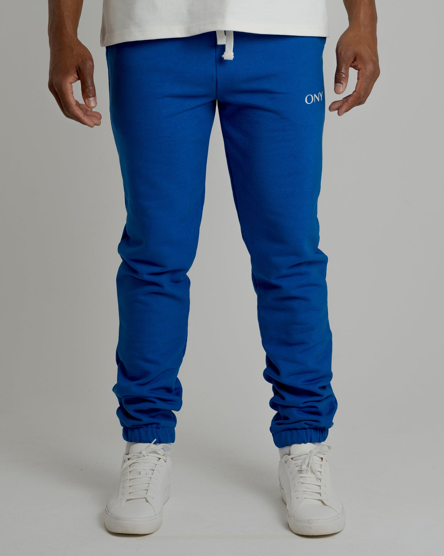 A male model showcasing our blue sweatpants, combining comfort and style in a versatile wardrobe essential. 