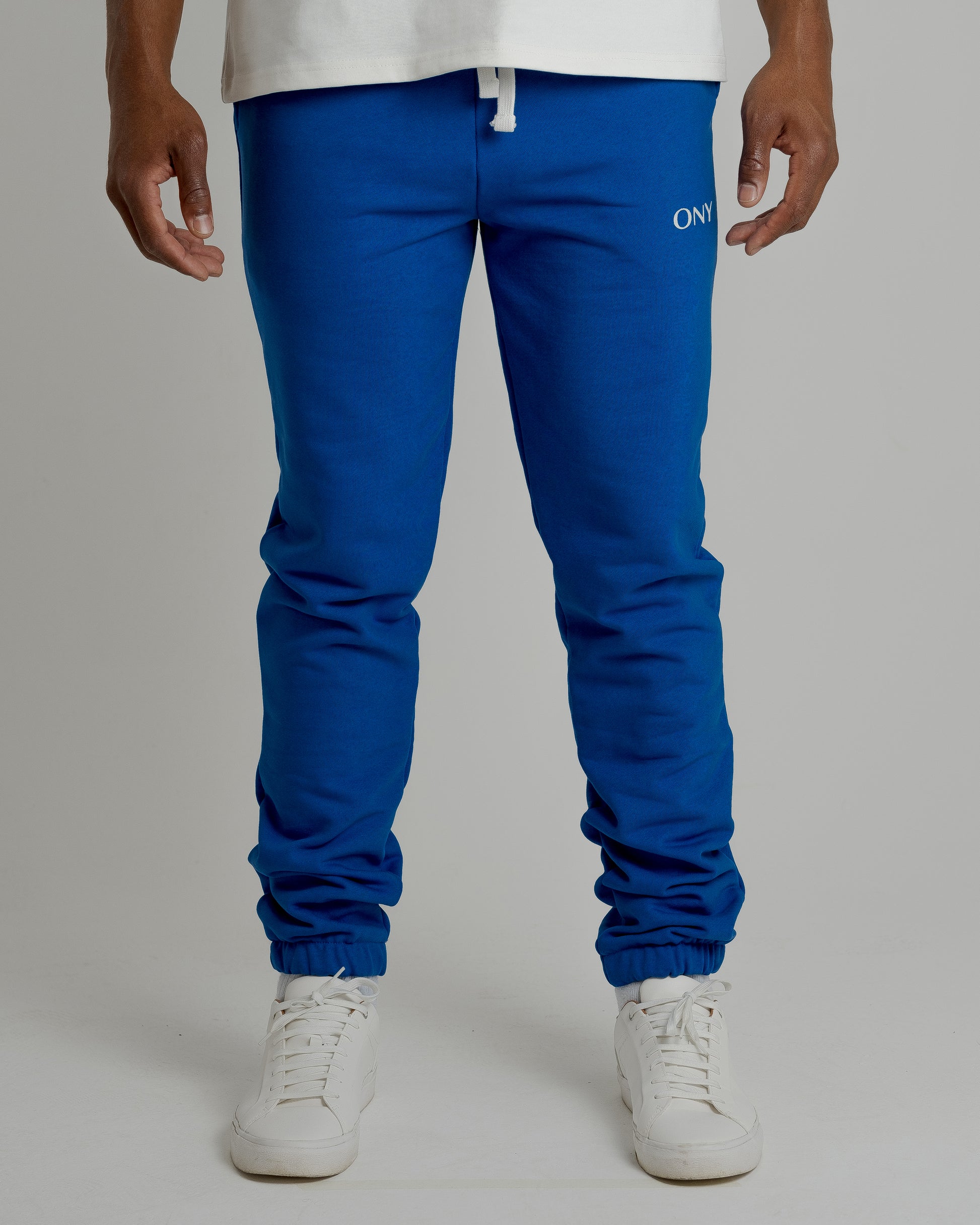 A male model showcasing our blue sweatpants, combining comfort and style in a versatile wardrobe essential. 