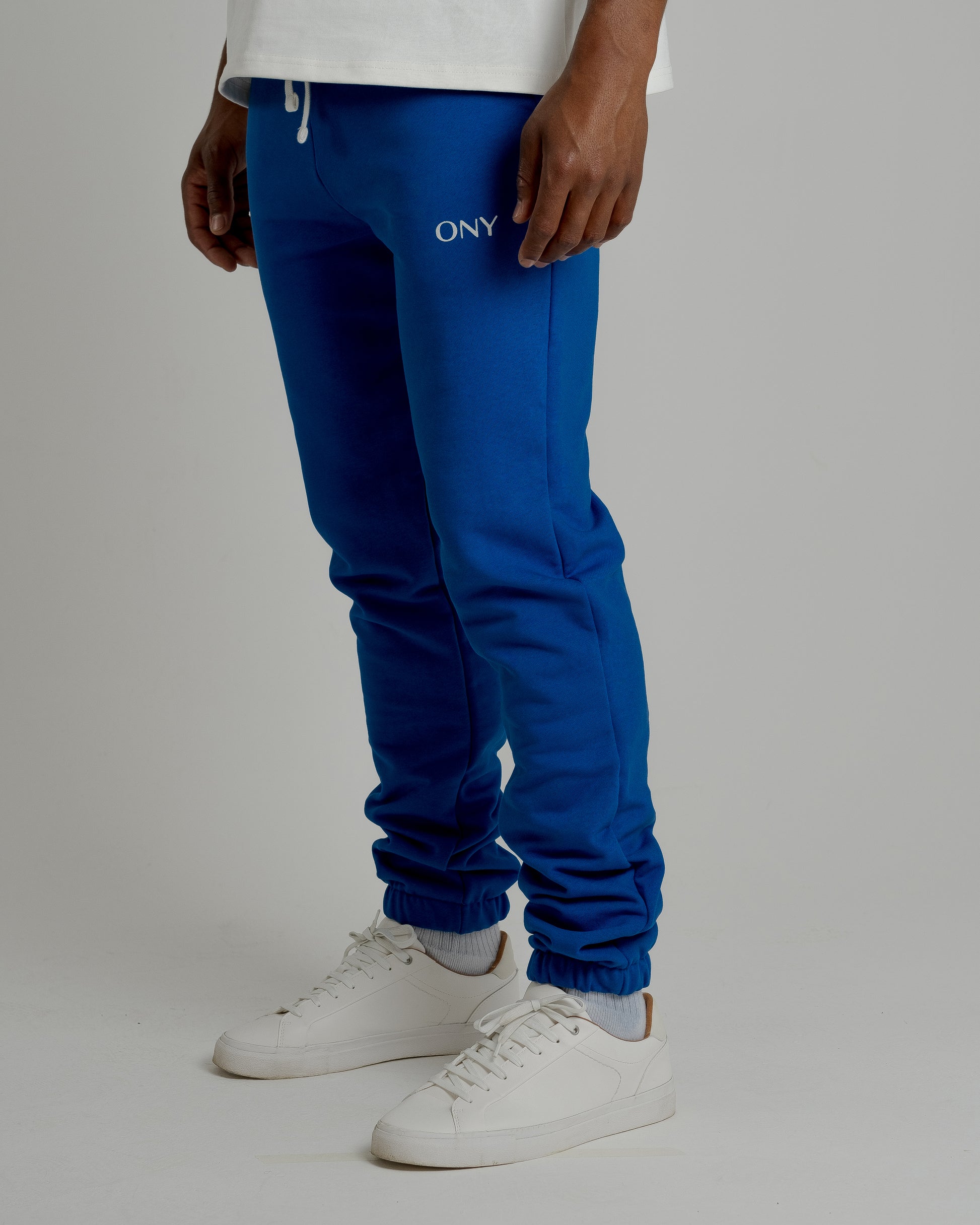 A male model showcasing our blue sweatpants, combining comfort and style in a versatile wardrobe essential. 