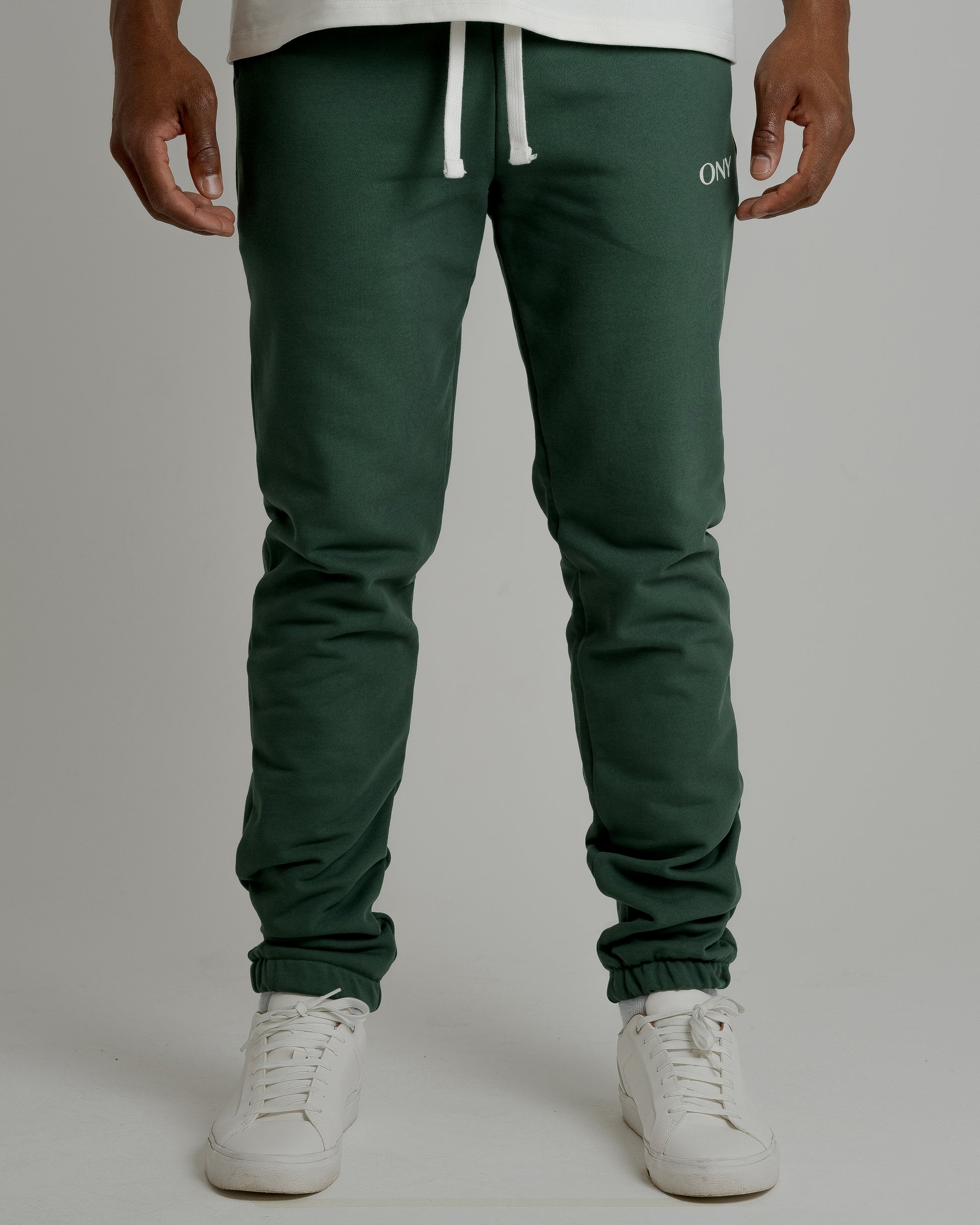 A male model showcasing our green sweatpants, combining comfort and style in a versatile wardrobe essential. 