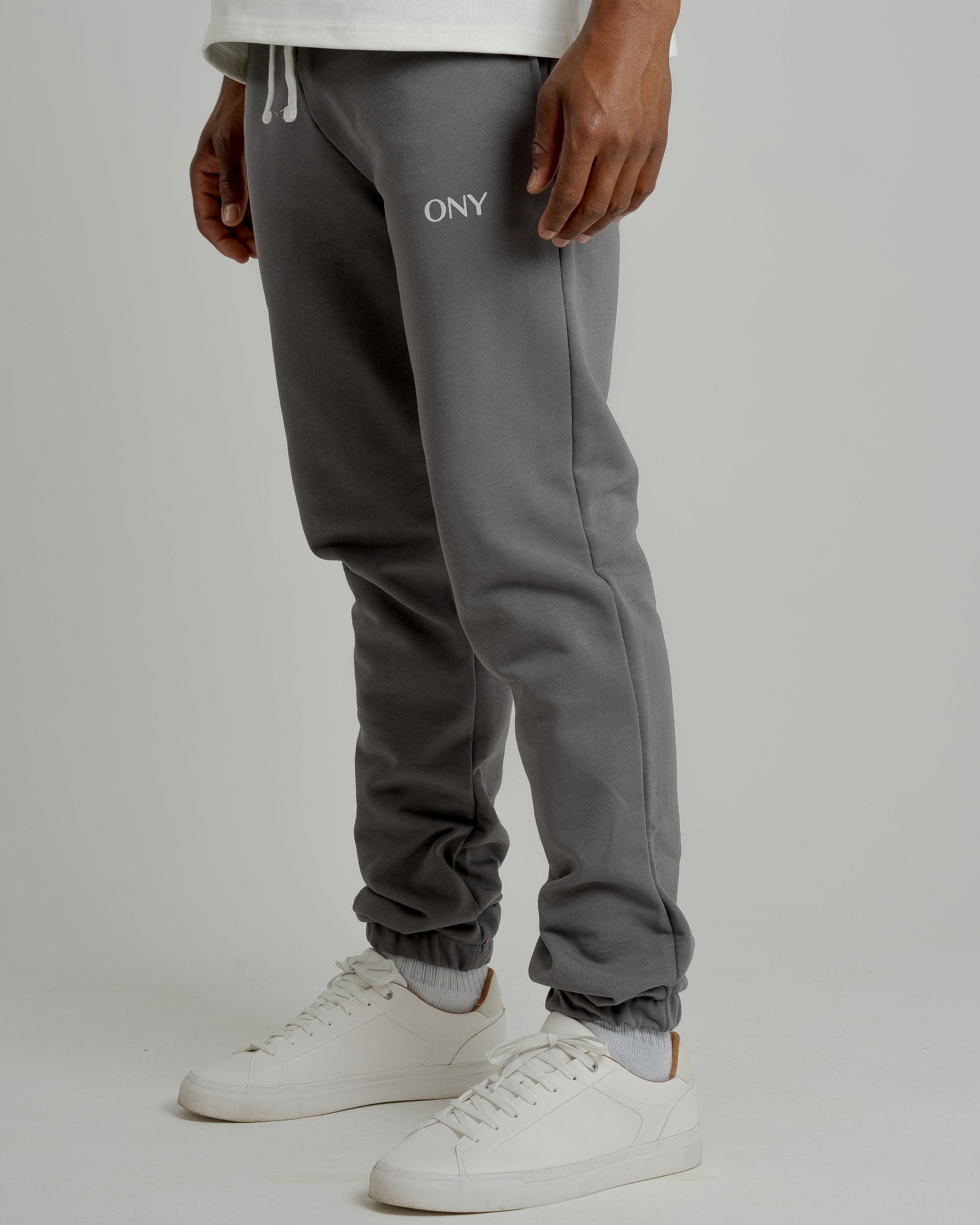 A male model showcasing our grey sweatpants, combining comfort and style in a versatile wardrobe essential. 