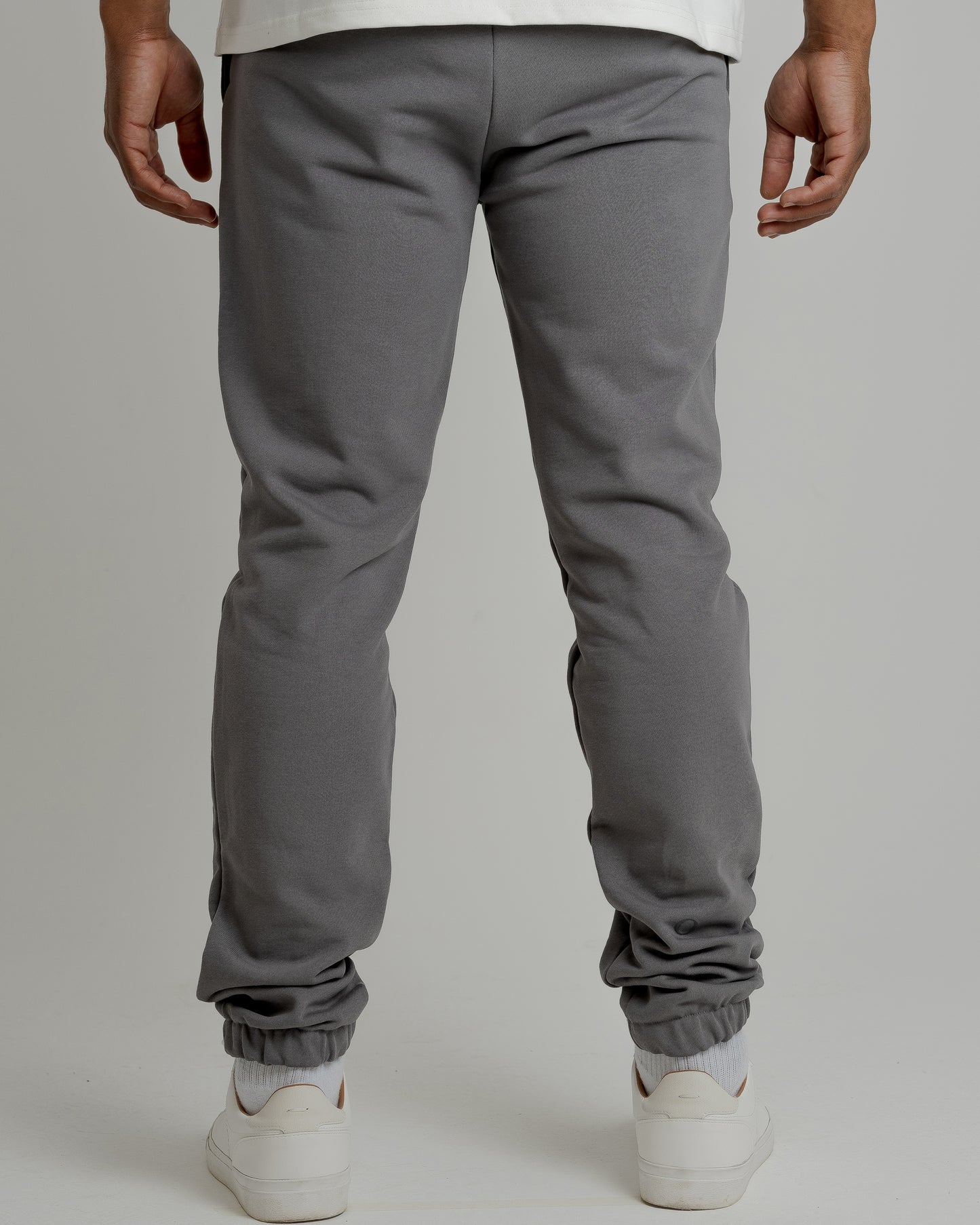 A male model showcasing our grey sweatpants, combining comfort and style in a versatile wardrobe essential. 