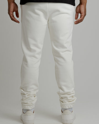 A male model showcasing our off-white sweatpants, combining comfort and style in a versatile wardrobe essential. 