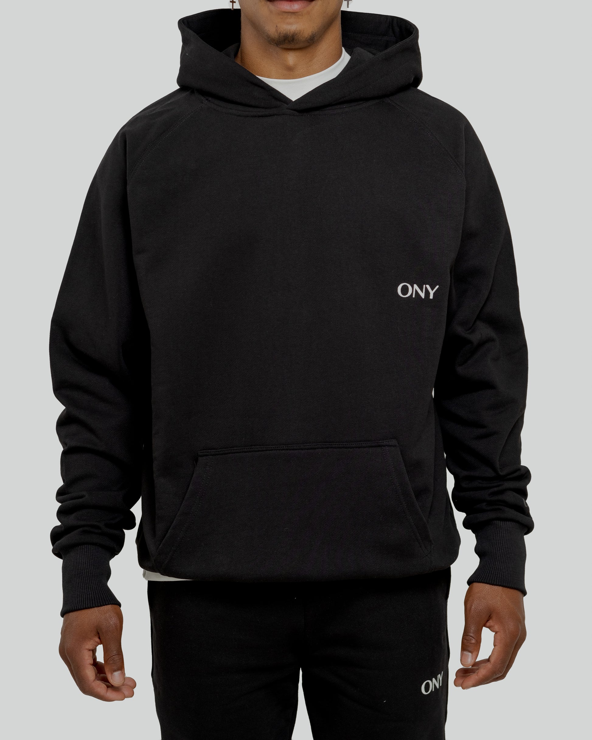 A male model wearing a stylish black oversized hoodie, perfect for a comfortable and fashionable look.  