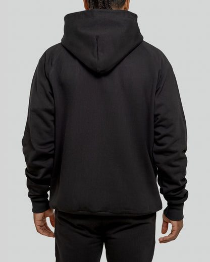 A male model wearing a stylish black oversized hoodie, perfect for a comfortable and fashionable look.  