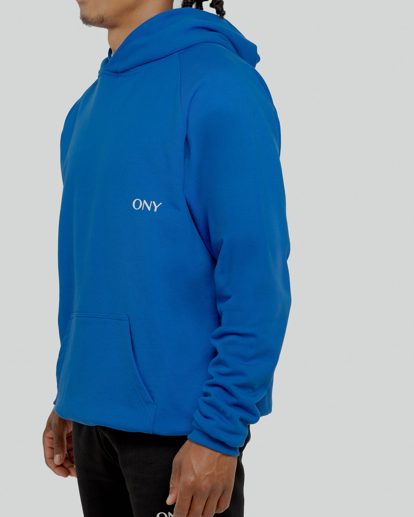 A male model wearing a stylish blue oversized hoodie, perfect for a comfortable and fashionable look.  