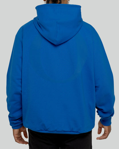 A male model wearing a stylish blue oversized hoodie, perfect for a comfortable and fashionable look.  