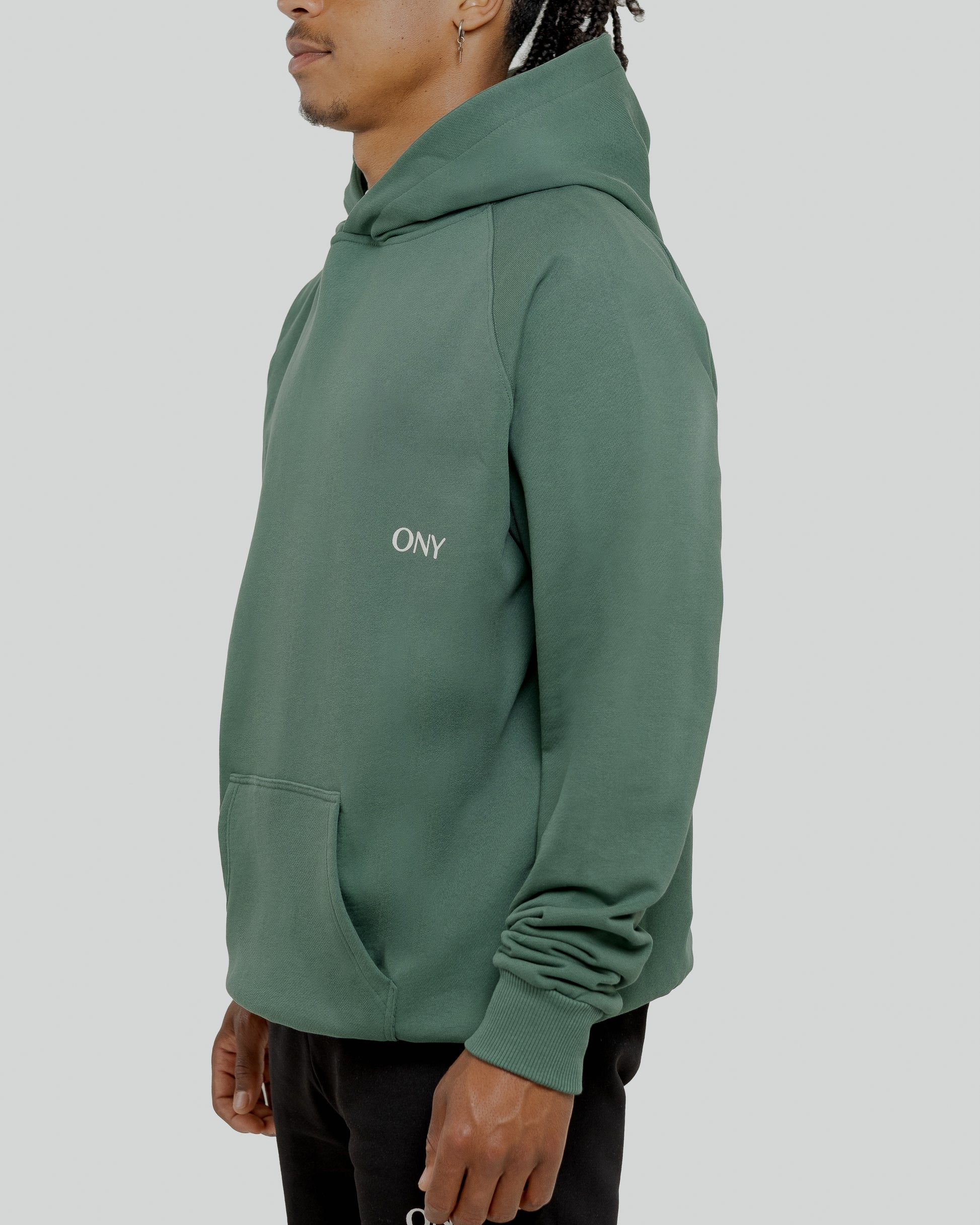 A male model wearing a stylish green oversized hoodie, perfect for a comfortable and fashionable look.  