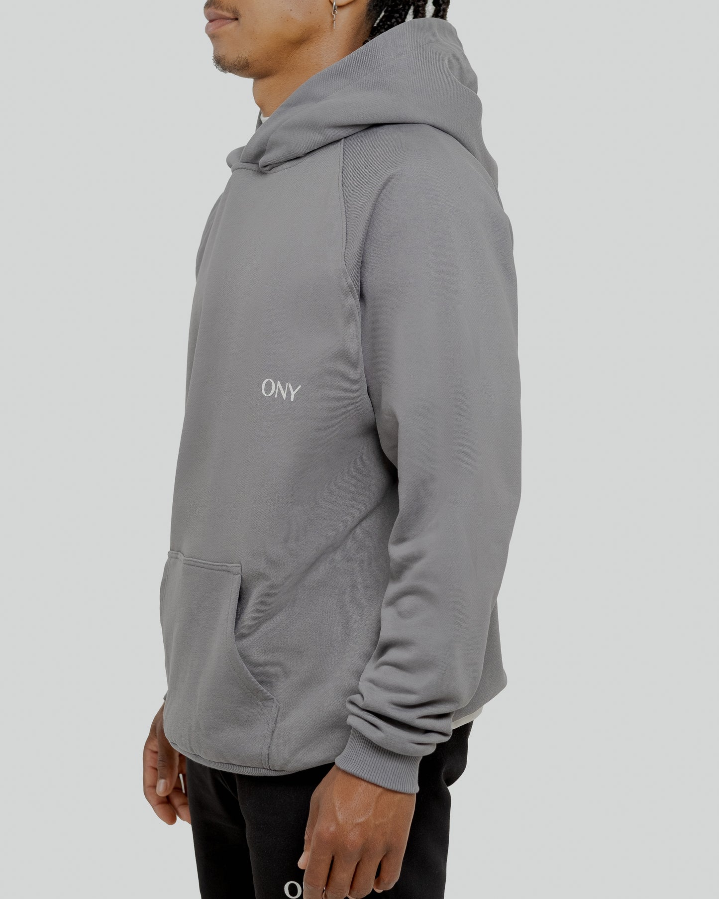 A male model wearing a stylish grey oversized hoodie, perfect for a comfortable and fashionable look.  