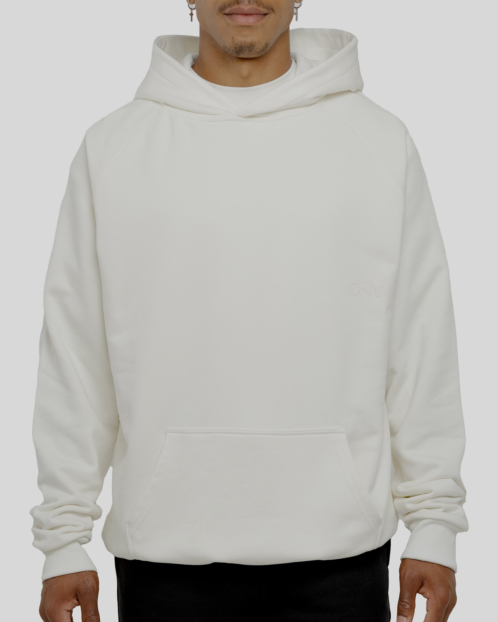 A male model wearing a stylish off-white oversized hoodie, perfect for a comfortable and fashionable look.  