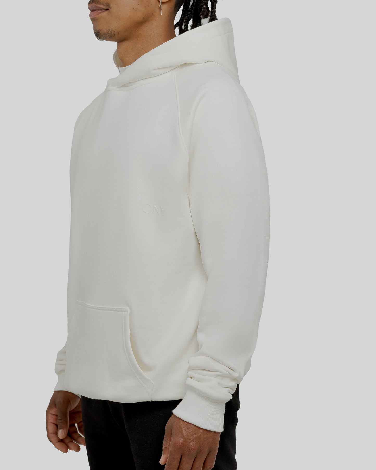 A male model wearing a stylish off-white oversized hoodie, perfect for a comfortable and fashionable look.  