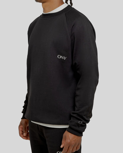 A male model wearing our black oversized sweatshirt, exuding a casual and stylish vibe for a modern wardrobe.