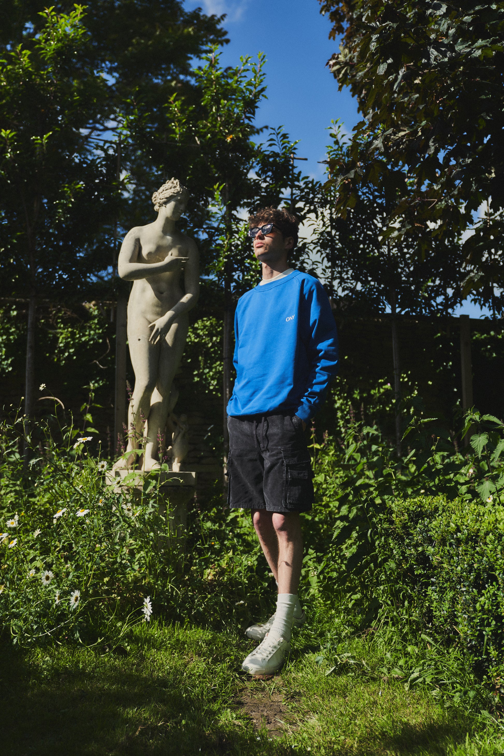 A male model wearing our blue oversized sweatshirt, exuding a casual and stylish vibe for a modern wardrobe.