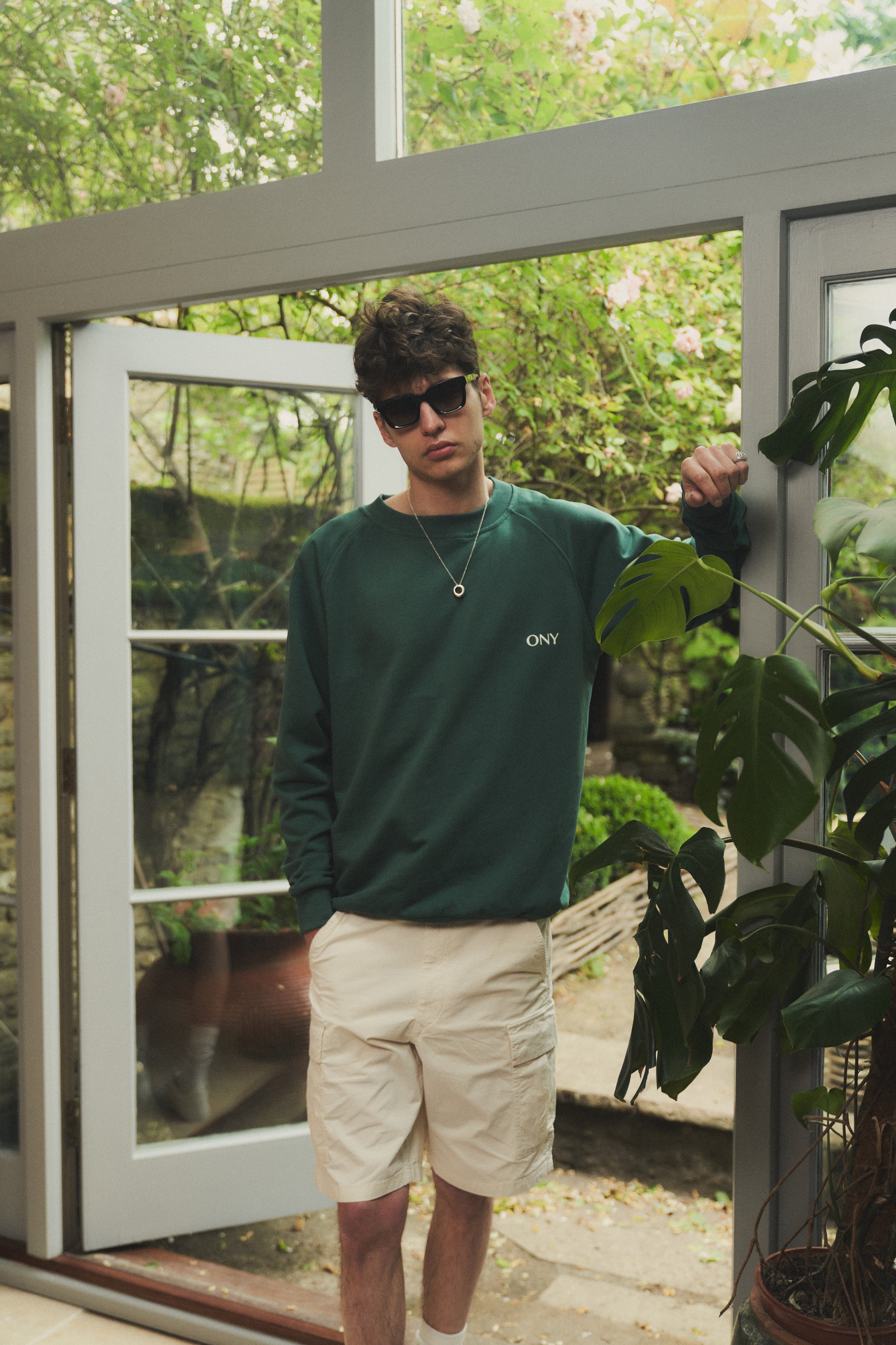 A male model wearing our green oversized sweatshirt, exuding a casual and stylish vibe for a modern wardrobe.