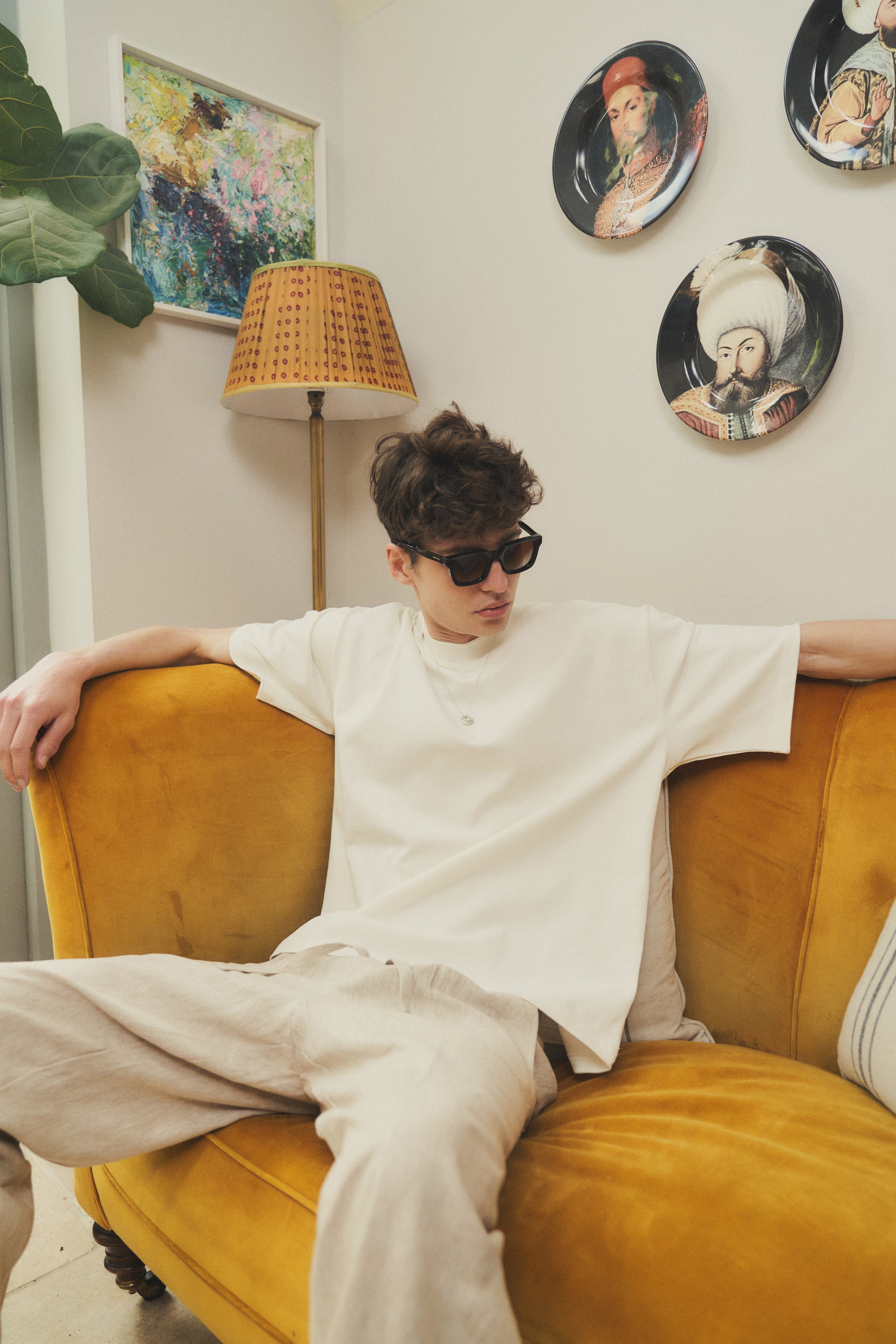 A male model wearing our off-white oversized tee with a slightly cropped body length and a boxy fit, perfect for a modern and relaxed look. 