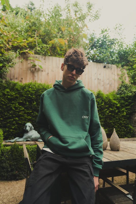 A male model wearing a stylish green oversized hoodie, perfect for a comfortable and fashionable look.  
