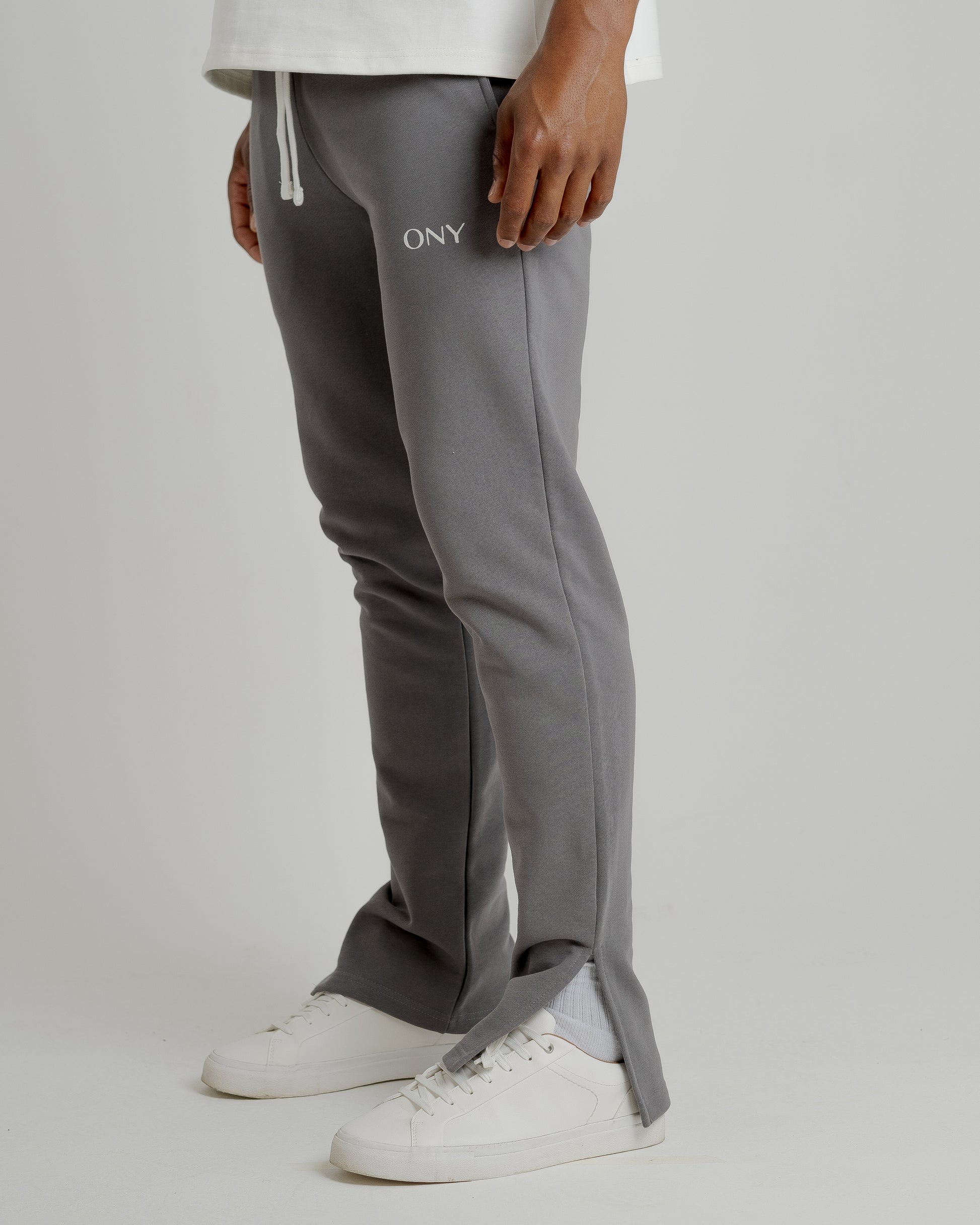 A male model wearing our grey split sweatpants for a laid-back yet fashionable look.