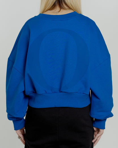 A female model wearing our blue women's cropped sweatshirt, exuding a casual and stylish vibe for a modern wardrobe.